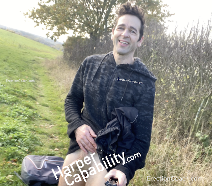 man in a field with trousers pulled down - so smiling excitedly but with text covering his penis